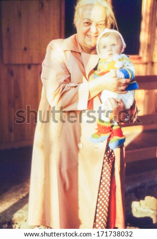 Vintage photo (scanned reversal film) of grandmother with a baby granddaughter, 1981