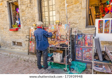 MONTREAL, CANADA, OCTOBER 12, 2013 - artist painting and selling his art in the street of Old Montreal