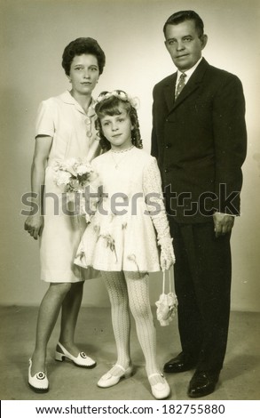 LODZ, POLAND - CIRCA 1970\'s: Vintage photo of little girl with her parents at his First Communion