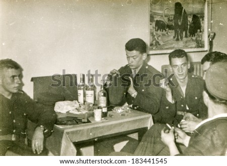 LODZ, POLAND, CIRCA 1970\'s: Vintage photo of  group of servicemen drinking alcohol and smoking together