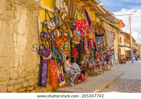 PERU, OLLANTAYTAMBO, MAY 4, 2014 - . Souvenirs\' sellers sit in front of their boutique in Plaza de Armas