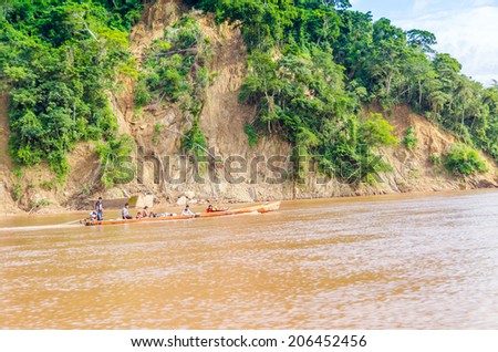 RURRENABAQUE, BOLIVIA, MAY 11, 2014 - Local people travel in traditional wooden boat on Beni river