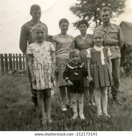 SIERADZ, POLAND, CIRCA FIFTIES - Vintage photo of two soldiers with their wives and children