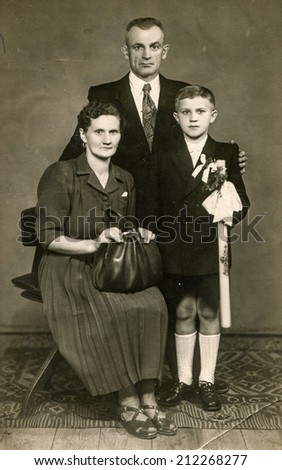 SIERADZ, POLAND, CIRCA FIFTIES - Vintage photo of parents with their son at his First Communion
