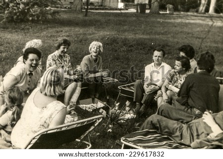 USTRONIE, POLAND, CIRCA SIXTIES: Vintage photo of group of people parting in garden