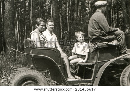 POLAND, CIRCA SIXTIES: Vintage photo of parents with little son traveling by horse-drawn carriage