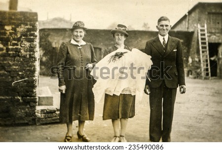 GERMANY, AUGUST 19, 1941: Vintage photo of parents and grandmother with their child after baptising