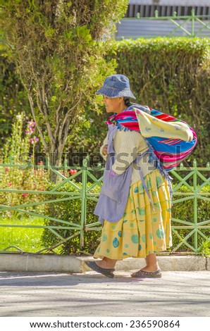 LA PAZ, BOLIVIA, MAY 8, 2014:  Local woman in traditional attire walks at Plaza Murillo