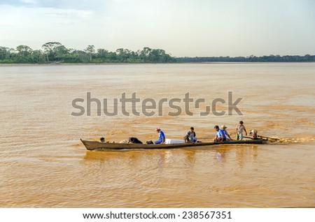 RURRENABAQUE, BOLIVIA, MAY 10, 2014 - Local people travel in traditional wooden boat on Beni river