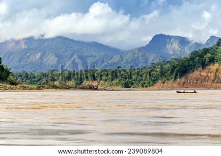 RURRENABAQUE, BOLIVIA, MAY 11, 2014: Local people travel in traditional wooden boat on Beni river