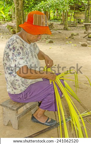 SAN MIGUEL DEL BALA, BOLIVIA, MAY 11, 2014: Local woman shows how to make a fan from palm leaves