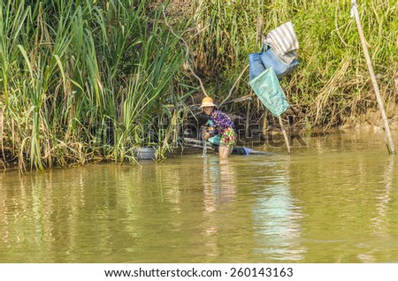 CHAU DOC, VIETNAM - JANUARY 2, 2013: Rural life in Mekong delta- Local woman washes clothes in Bassac River