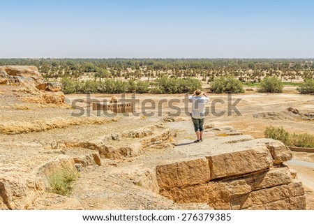 Tafilalt oasis in Morocco - senior tourist looks the landscape from Tinrheras ksar