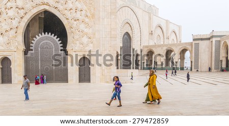 CASABLANCA, MOROCCO, APRIL 2, 2015: Local family walks on the outside grounds of Hassan II Mosque or Grande Mosquee Hassan II by misty morning