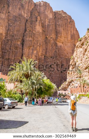 TINERHIR, MOROCCO, APRIL 11, 2015: Local people and tourists trek on shore of Todgha river in Todgha Gorge