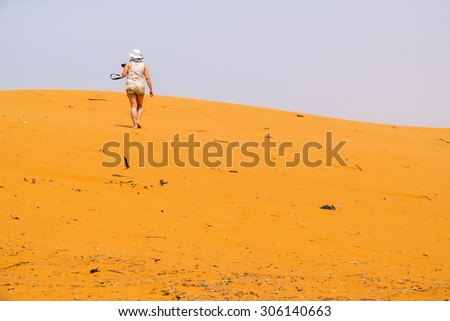 Female tourist on sand dunes in Merzouga, Morocco