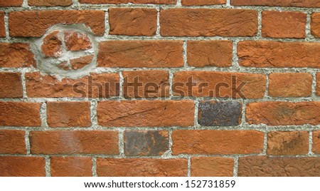 Red brick wall with badly repaired circular hole - horizontal