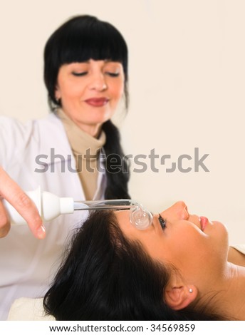 Girl, getting face massage a static electricity.