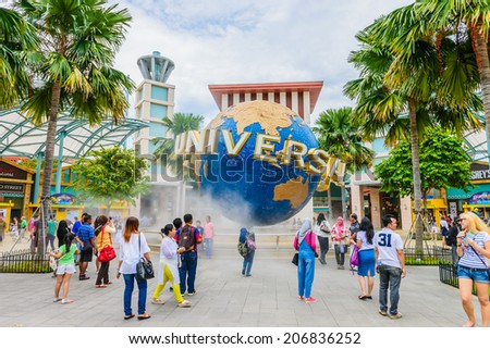 SINGAPORE - JUNE 25: Tourists and theme park visitors taking pictures of the large rotating globe fountain in front of Universal Studios on JUNE 25, 2014 in Sentosa island, Singapore