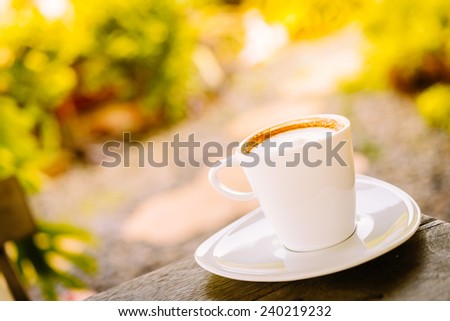 White coffee cup latte on wooden table - vintage sunlight effect style pictures