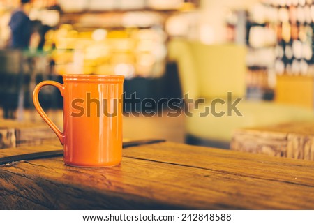 Red Coffee mug on wooden table in coffee shop - Vintage effect style pictures processing