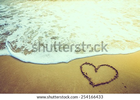 Wave sea water on the beach with heart symbol - vintage effect style pictures