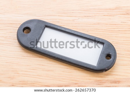 Name tag luggage on wooden background
