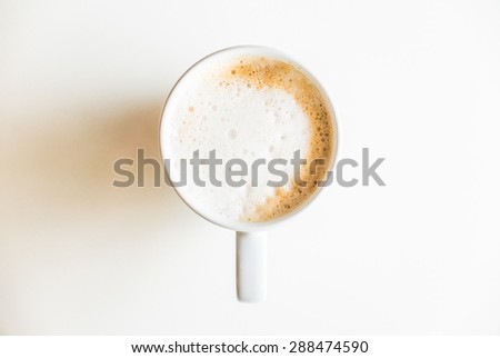 Top of view coffee cup on white table with hard light from side window