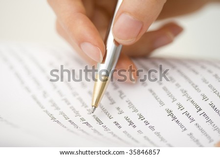 BUSINESS IMAGE-a hand checking the document with a silver pen