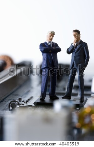 Dolls of the businessman who communicates in the electronic machine.