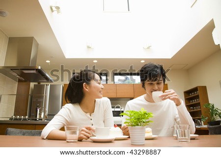 A young couple chatting and smiling in the kitchen