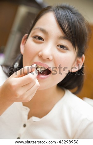 A young woman having a cake and smiling