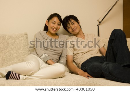 A young couple sitting on the sofa together