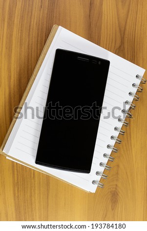 Note book and smartphome on the wooden table