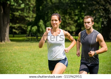 Couple jogging - young man and woman competing, woman first