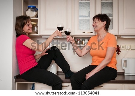 Happy life - mother and daughter drinking wine