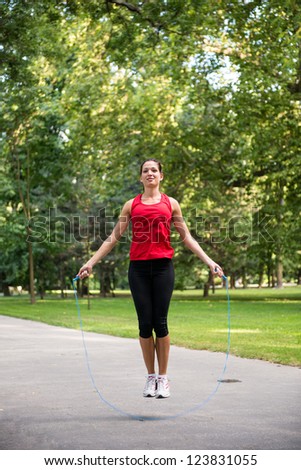 Young fitness woman exercising - jumping with skipping rope
