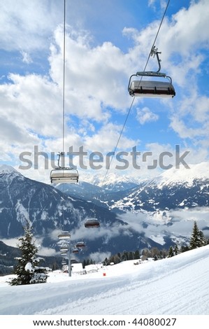 Empty ski lift in beautiful winter snowy mountain landscape (resort in Alps)