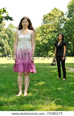 One girl is offended and her friend is calling for her - outdoors in park
