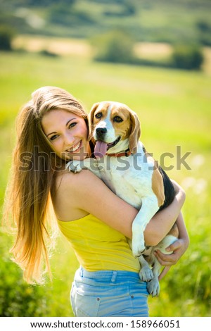 Portrait of young woman with her pet (beagle dog) - outside in nature
