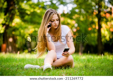 Young beautiful woman (teen girl) with 2 mobile phones - mobility concept