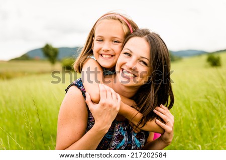 Mother and child are hugging and having fun outdoor in nature