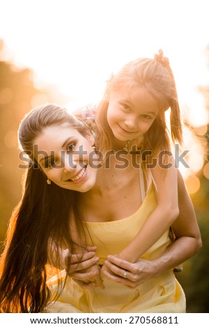Portrait of mother with child enjoying together in sunny nature