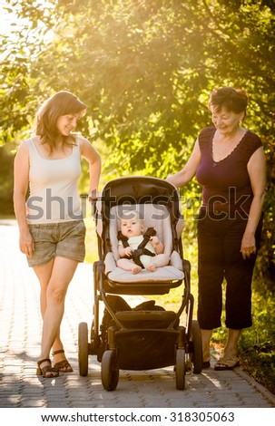 On a walk - grandmother with her daughter and her granddaughter in stroller