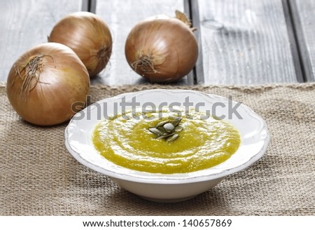 Creamy onion soup on wooden table