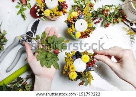 Florist at work. Woman making autumn floral decorations