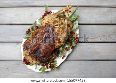 Baked goose on wooden table. Popular christmas dish
