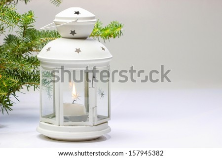 White lantern and fir branches on white background