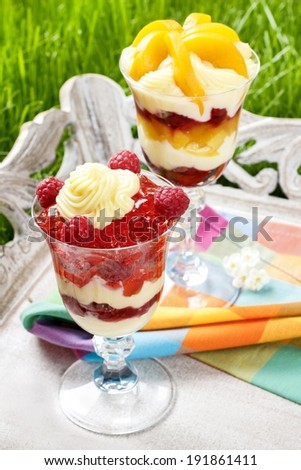 Layer fruit desserts on wooden tray. Summer garden party