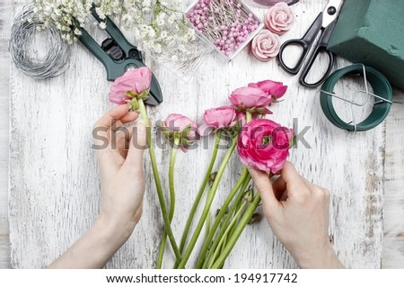 Florist at work. Woman making beautiful bouquet of pink persian buttercup flowers (ranunculus asiaticus)